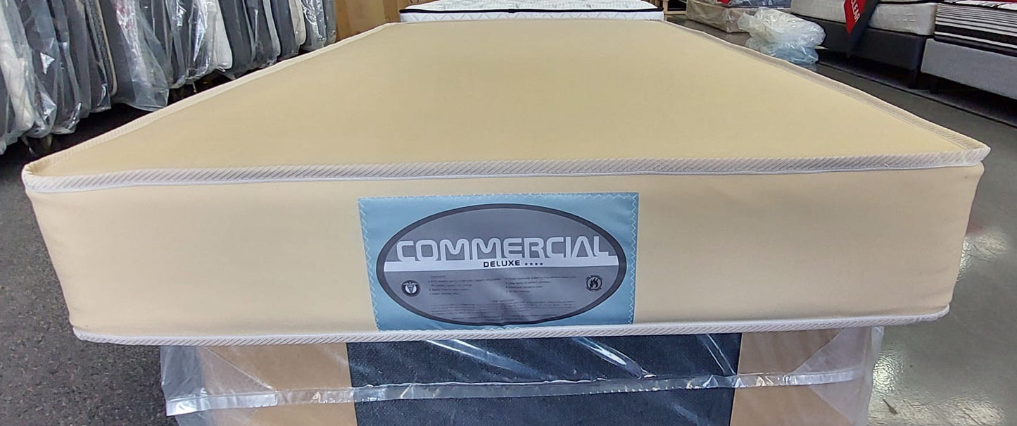 Beige commercial deluxe mattress with label in showroom, wrapped mattresses in background