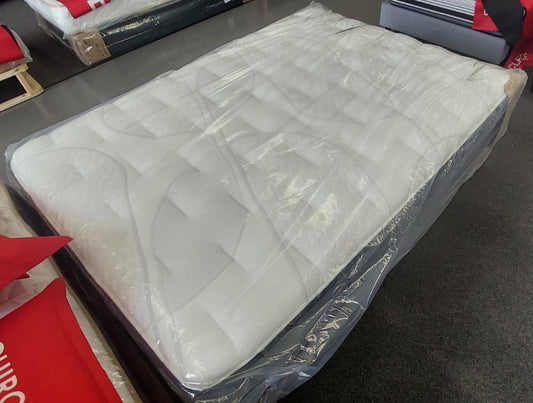 New white mattress in protective plastic cover on showroom floor