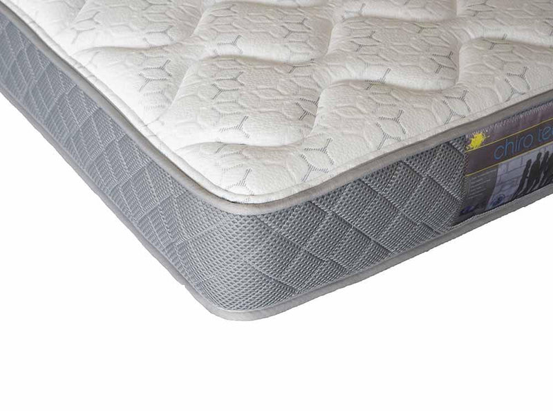 Close-up of a grey and white mattress with quilted sides and textured top surface.