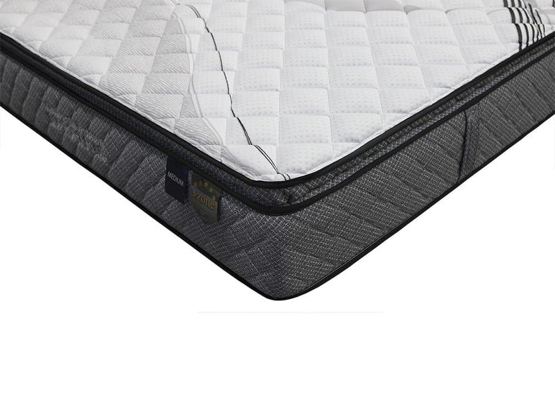 Close-up of a medium feel, grey and white mattress with quilted top and 5 zone support label