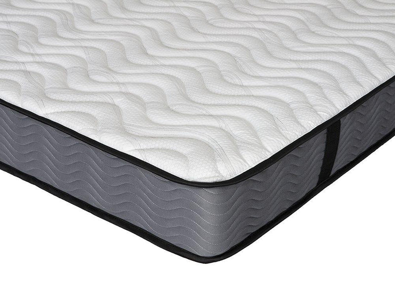 Close-up of modern mattress corner with textured white top and grey fabric sides