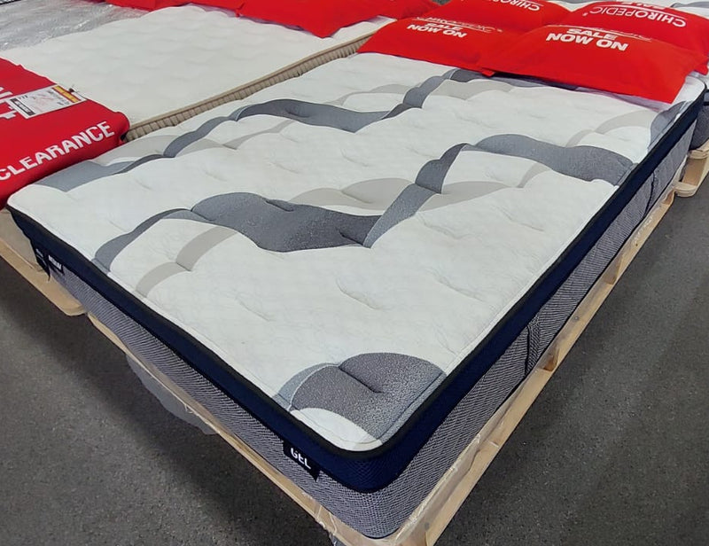 Side view of a gel memory foam mattress with a white and grey textured top on display