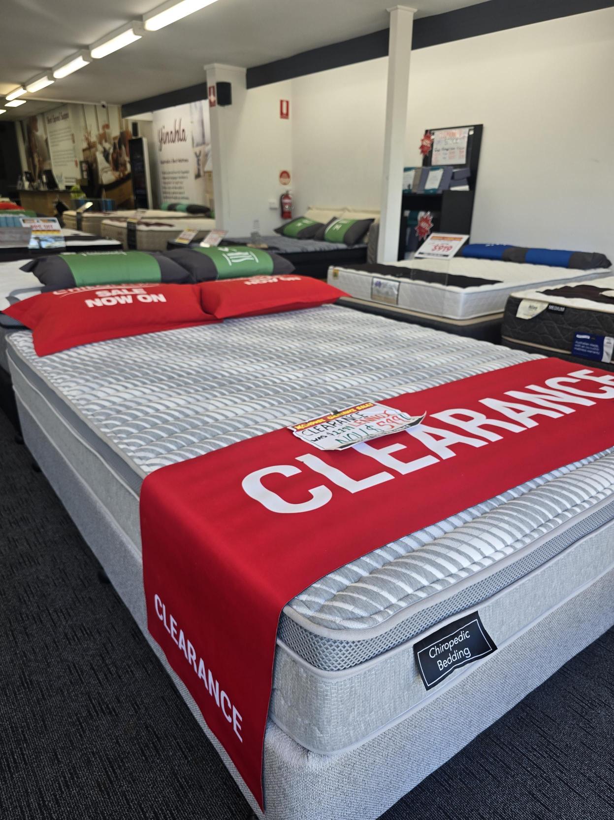 Mattress store showroom with clearance sale mattresses, including chiropractic bedding.