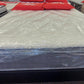 Factory-direct mattress wrapped in plastic on display with red sale signs