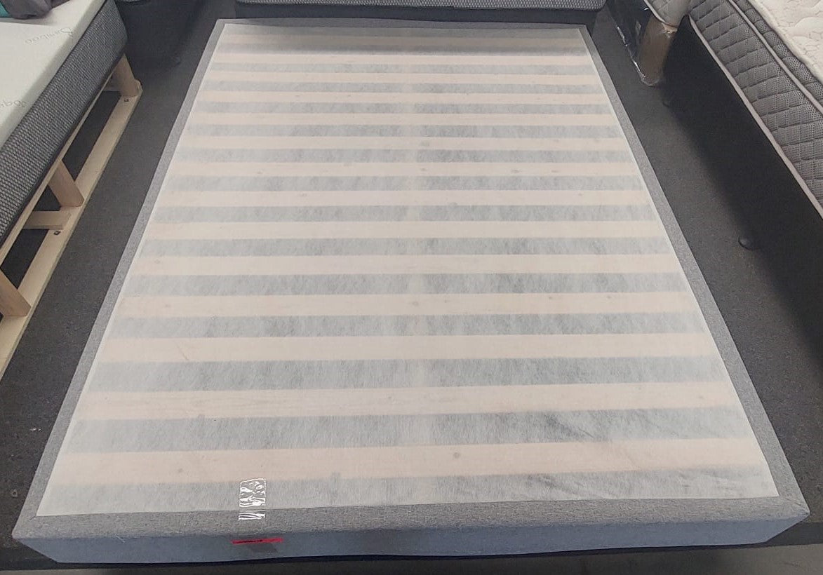 Factory direct upholstered bed base with wooden slats in a mattress showroom