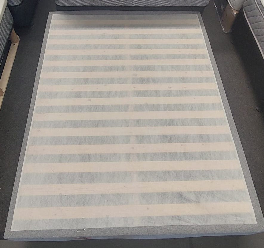 Wood slat bed base frame for mattress in showroom setting