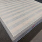 Factory direct mattress with striped top and grey edge on showroom floor
