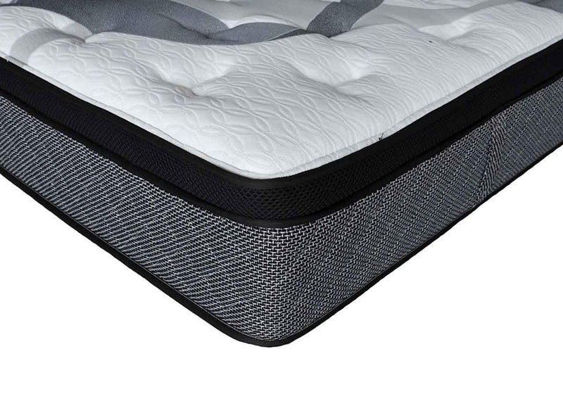 Close-up of a modern hybrid mattress with quilted white top and grey mesh sides