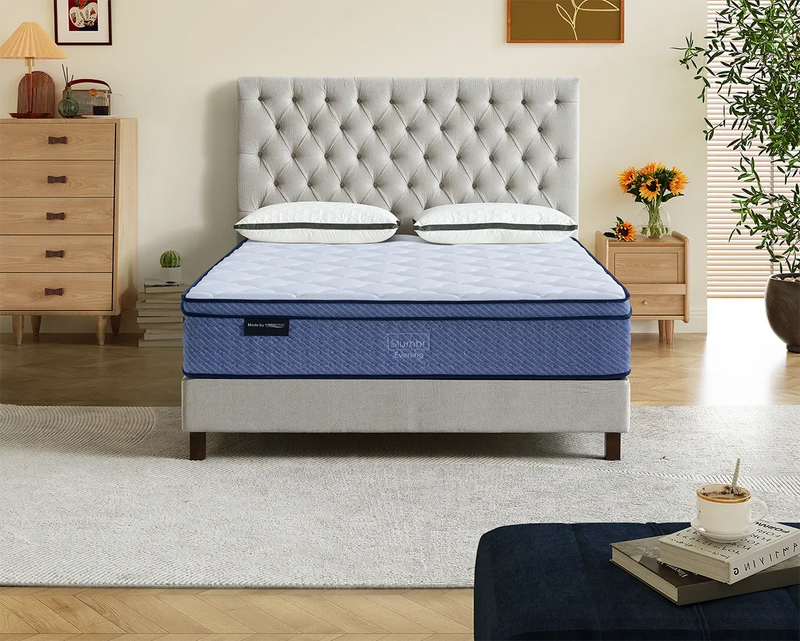 Modern bedroom with a blue mattress on a tufted bed frame, bedside tables, and decor accents